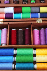 Fototapeta na wymiar Colorful threads for needlework in wooden box close up
