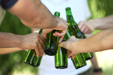 Hands holding beer bottles close up