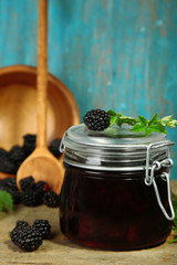 Fototapeta na wymiar Tasty blackberry jam and fresh berries, on wooden table