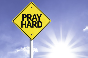 Pray Hard road sign with sun background
