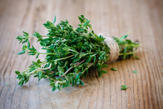 bunch of fresh thyme on a wooden background
