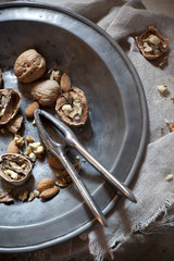 craked walnuts with nutcraker on vintage plate