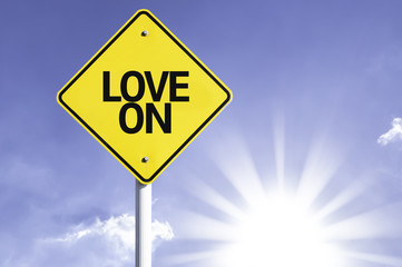 Love On road sign with sun background