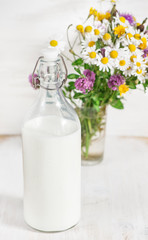 Fresh milk in old fashioned bottle and wildflowers