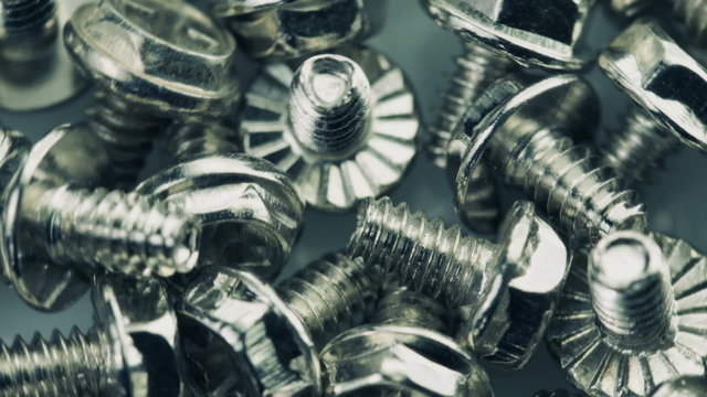 Close-up of steel bolts turning in a seamless loop.