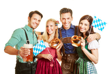 Freunde feiern Oktoberfest mit Bier und Brezel