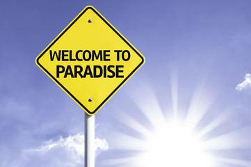 Welcome to Paradise road sign with sun background