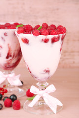 Tasty raspberry dessert with berries on pink wooden background