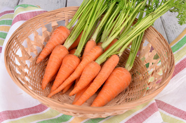 Fresh carrot in basket on table close up