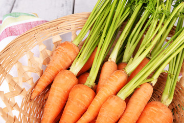 Fresh carrot in basket on table close up