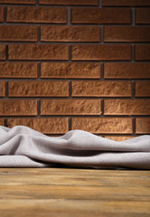 Naklejka na ściany i meble Wooden table with cloth on wall background
