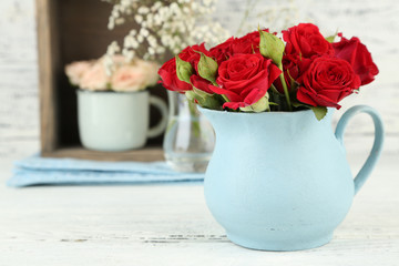 Beautiful flowers in vases on wooden background