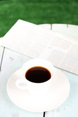 Cup of coffee on wooden table, outdoors