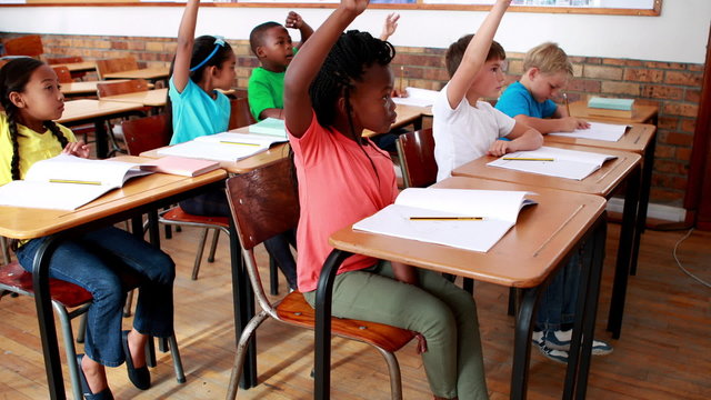 Pupils raising their hands during class