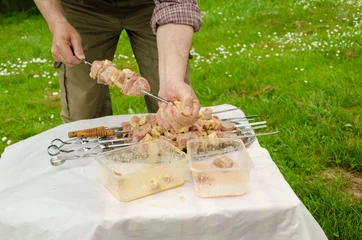 Foto op Canvas man put skewer green pork meat cooking on campfire © sauletas