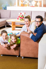Fototapeta na wymiar Familie kauft Couch in Möbel Geschäft 