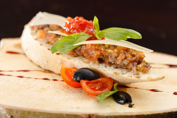 Italian appetizer bruschetta with tomato, basil and black olives