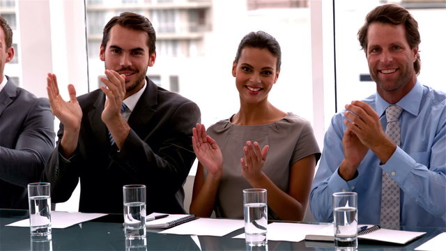 Business team applauding the camera at meeting