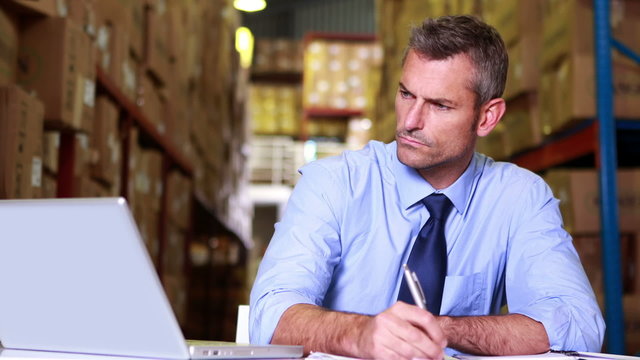 Warehouse manager working on laptop