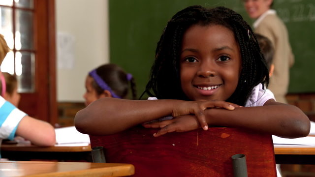 Cute little girl smiling at camera during class