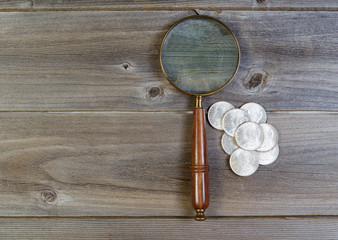 Silver dollar coin collection and round vintage magnify glass on