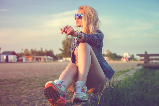 Beautiful fashion young woman sunglasses sitting and posing at