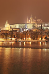 Fototapeta na wymiar Night snowy Prague gothic Castle with Charles Bridge
