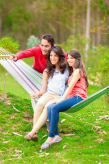 Fototapeta na wymiar two beautiful girls and a young man in hammock outdoors