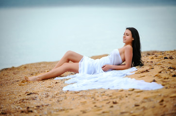 Fototapeta na wymiar woman in white fabric on beach