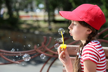 Cute girl blowing soap bubbles