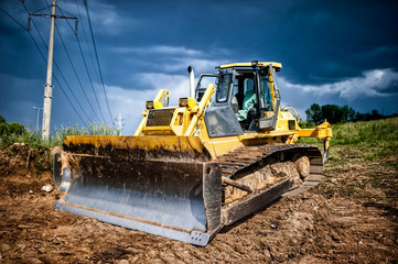 industrial backhoe, bulldozer moving earh and sand in sandpit