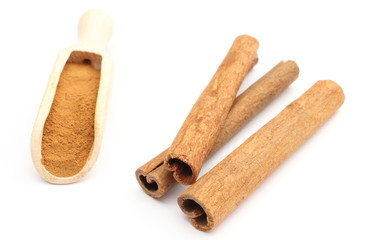 Powdery and stack of cinnamon sticks on white background
