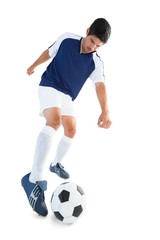 Football player in blue kicking ball