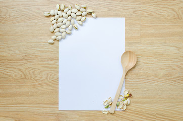 Paper with spoon and pistachios