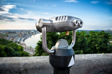 Binocular next to the waterside promenade to the city and river