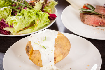 Baked jacket potato with sour cream sauce