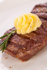 Grilled beef steak topped with butter and rosemary