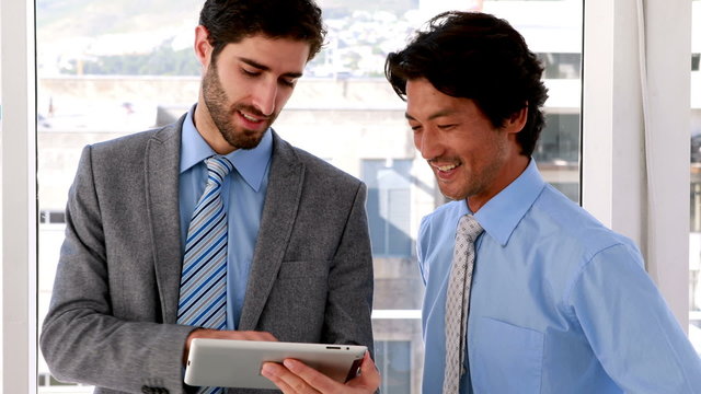 Businessman using tablet pc with his colleague