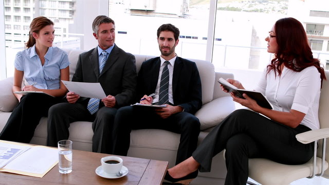 Business team sitting on couch having a meeting