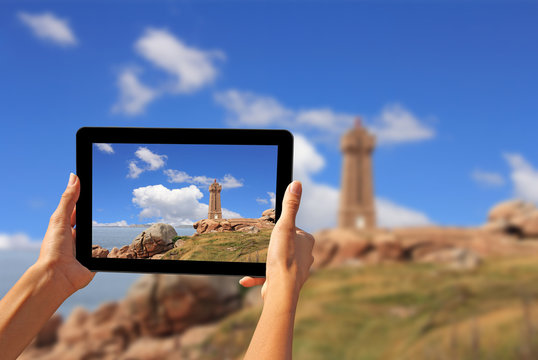 Woman taking pictures on a tablet lighthouse