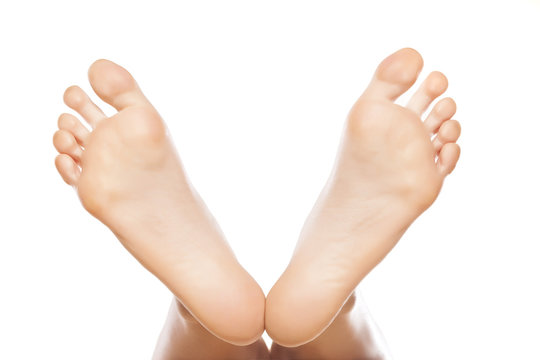 spread female feet on white background