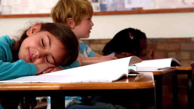 Cute little girl sleeping on desk during class