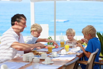 Family of four having healthy breakfast in outdoors cafe