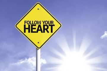 Follow your Heart road sign with sun background