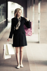 Fototapeta premium Young fashion woman with shopping bags walking in the mall