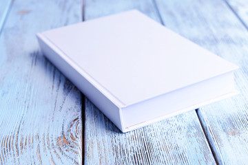 Fototapeta premium White book on wooden table