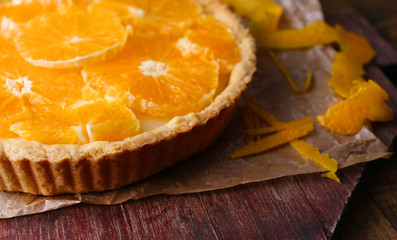 Homemade orange tart on wooden background