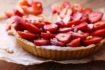 Strawberry tart on wooden tray, on rustic wooden background