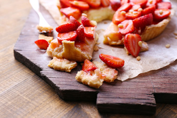 Strawberry tart on wooden tray, on rustic wooden background