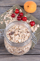 Homemade granola in glass jar, on color wooden background